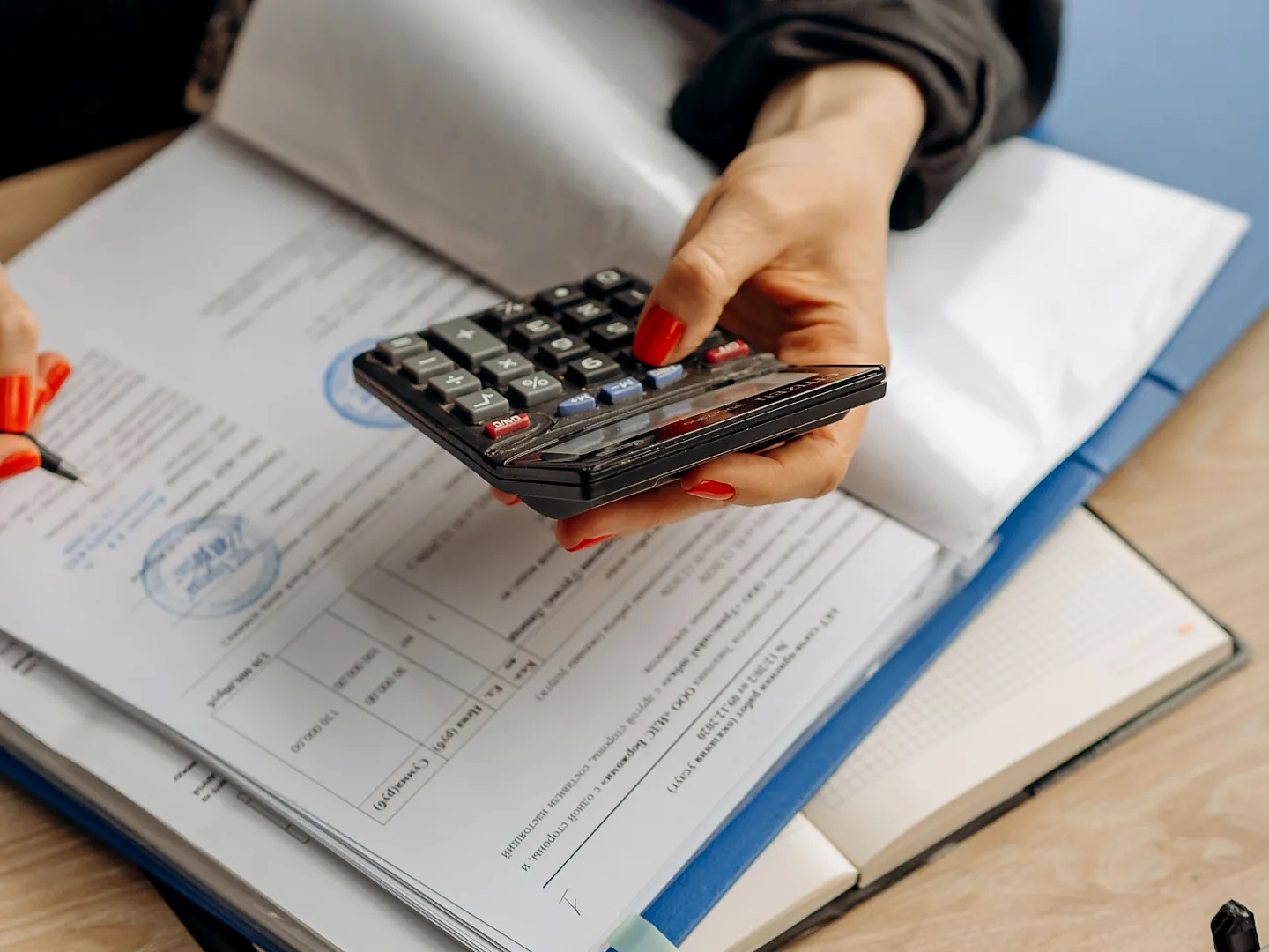 Professional calculating accounts with a calculator and financial documents