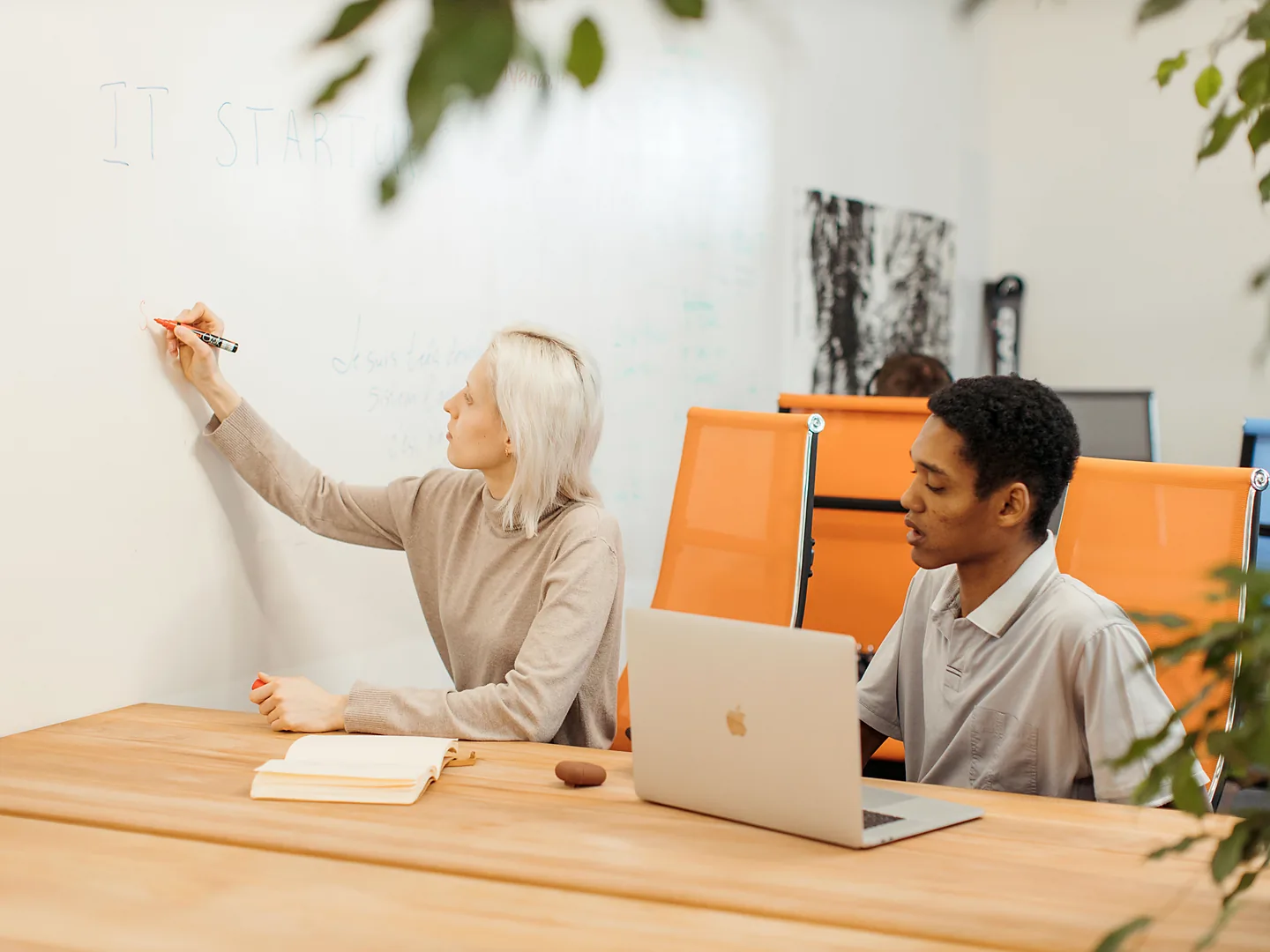 Startup founders planning their business with a laptop and whiteboard