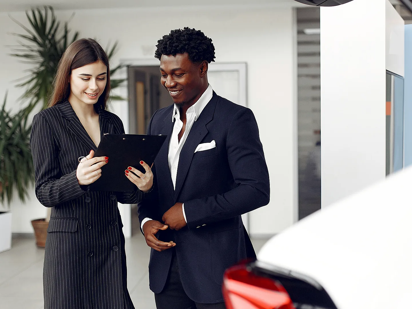 Car dealer and customer discussing vehicle finance documents